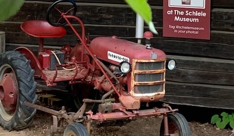 an old red farm tractor on display