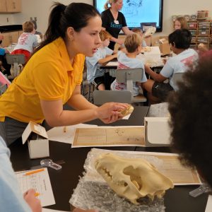 Instructor holding a fossil and explaining it to kids