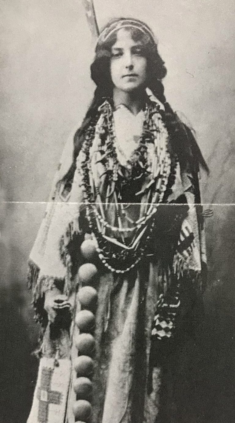 Black and white photo of Lilly Hobbs Schiele in Native American accessory