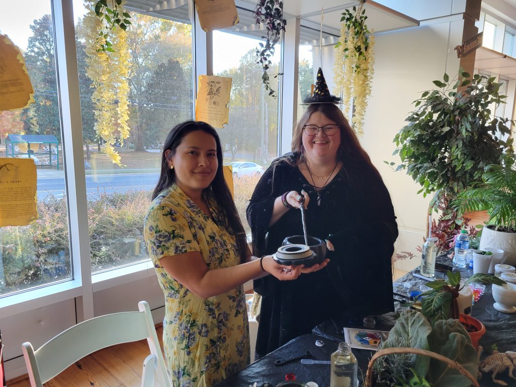 Picture of 2 women in witch costume posing for pictures for herbology