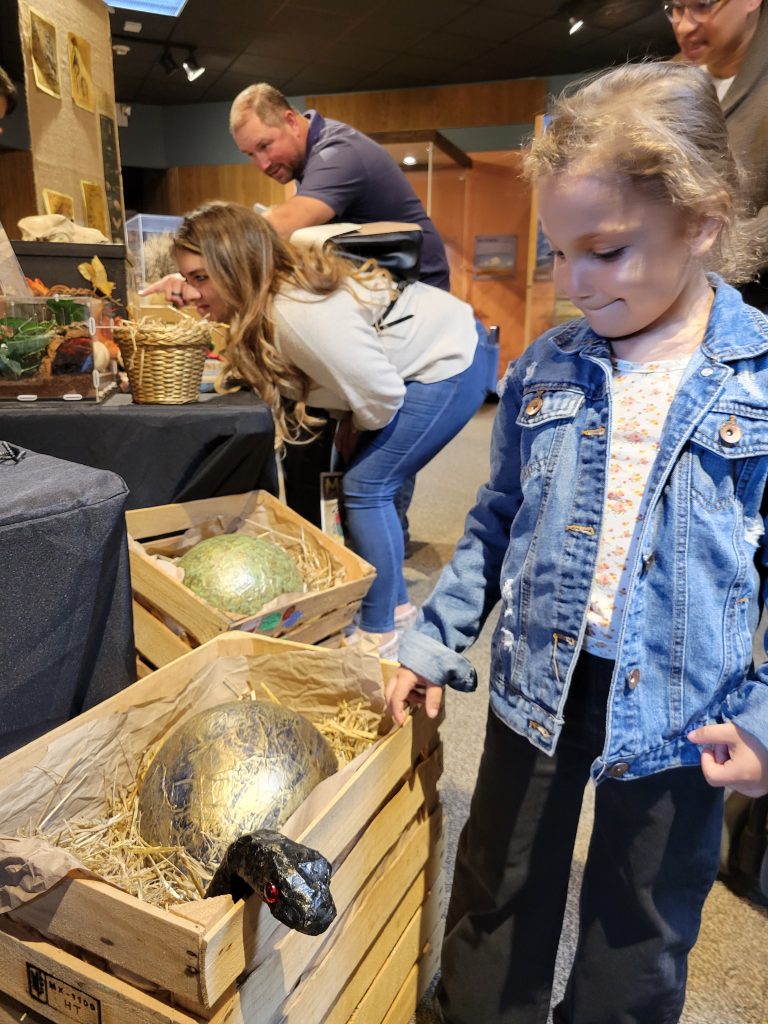 Photograph of a girl looking at a golden egg