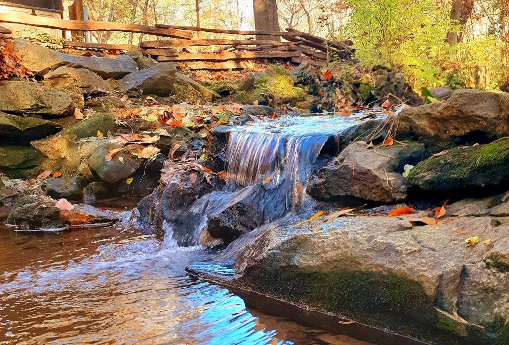 small waterfall of the creek in the Nature Trail during the fall season