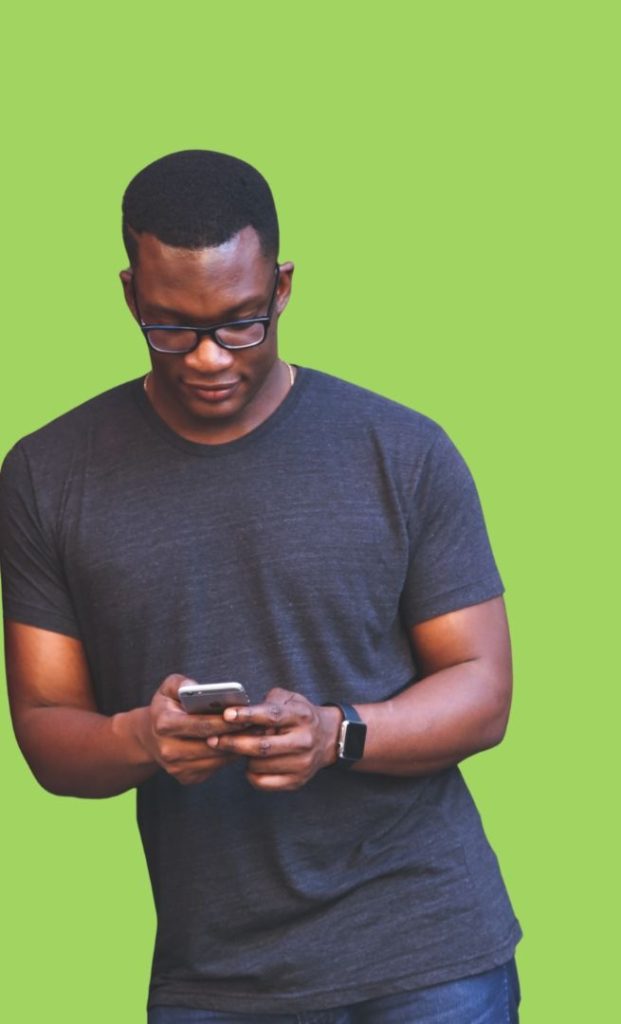 a black man leaning with glasses looking down at his cell phone