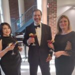 three partygoers in black formal attire